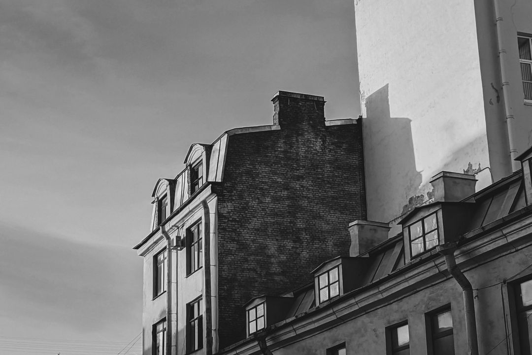 Old town houses in low evening sun against a pale sky, edited by Ivo