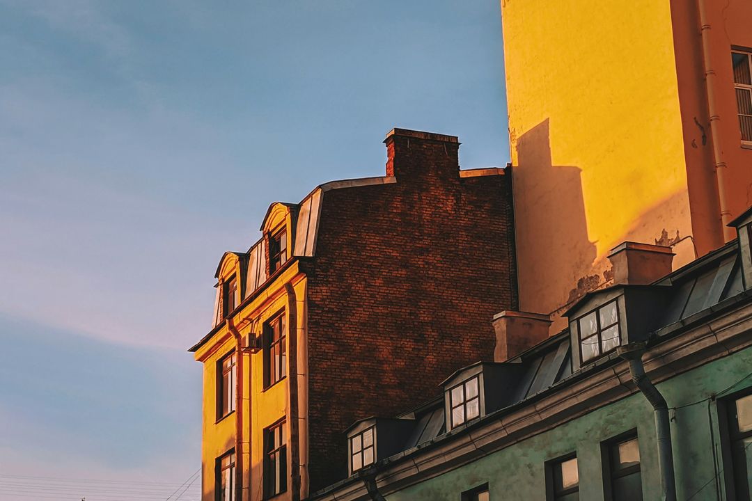 Old town houses in low evening sun against a pale sky